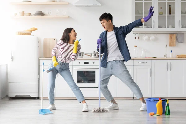 Engraçado asiático casal cantando canções enquanto a limpeza de cozinha, espaço cópia — Fotografia de Stock