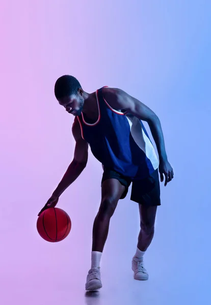 Retrato de comprimento total de determinado basquetebolista preto jogando bola na iluminação de néon — Fotografia de Stock