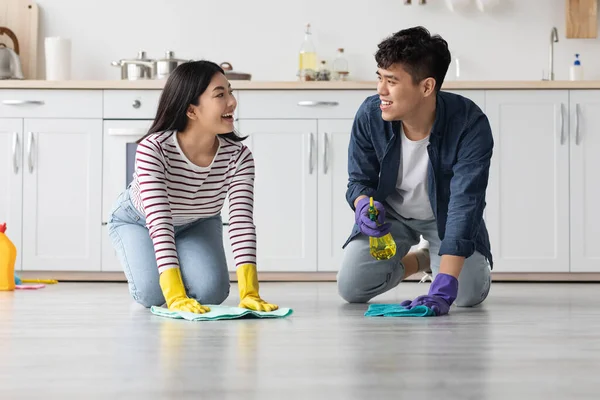 Jong aziatisch paar schoonmaken vloer in keuken en praten — Stockfoto