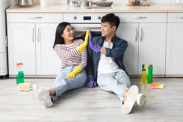 Moe aziatische paar zitten in keuken, geven high five — Stockfoto