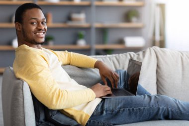 Genç Afro-Amerikan adam boş ekranlı defter kullanıyor.