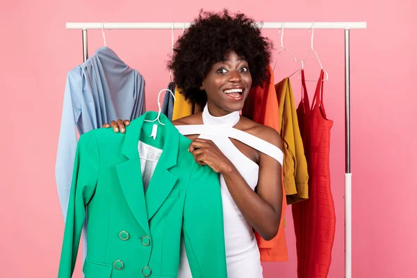 Emocionado negro mujer compras celebración brillante chaqueta posando, fondo rosa —  Fotos de Stock