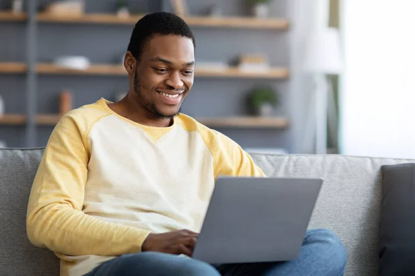 Χαμογελώντας Αφροαμερικανός που παρακολουθεί webinar, χρησιμοποιώντας φορητό υπολογιστή — Φωτογραφία Αρχείου