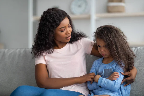 Jonge zwarte moeder troost boze en overstuur kleine meisje, knuffelen en troosten haar thuis. Het oplossen van gezinsconflicten — Stockfoto