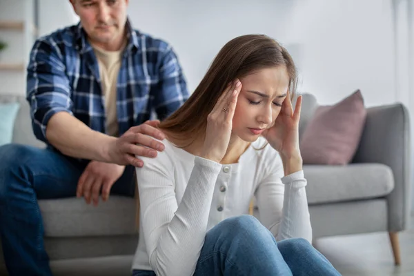 Mujer de mediana edad que se siente estresada, enfrenta problemas de salud, tiene problemas, su marido la apoya en casa —  Fotos de Stock