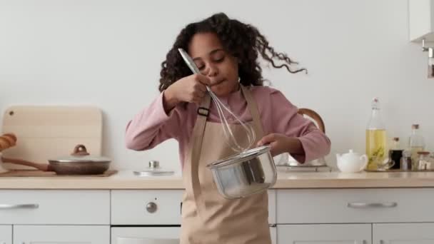 Szczęśliwa Afroamerykanka przygotowująca jajecznicę z ciastem w garnku i tańcząca sama w kuchni, zwolnione tempo — Wideo stockowe