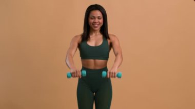 Afrikalı Kadın Egzersiz Yapıyor Bej Arkaplan Üzerinde Egzersiz Yaparken Dambılları Yükseltiyor