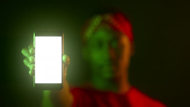 Modern smartphone med tom vit skärm i svarta manliga händer, suddigt porträtt av afrikansk amerikansk kille i neonljus — Stockvideo