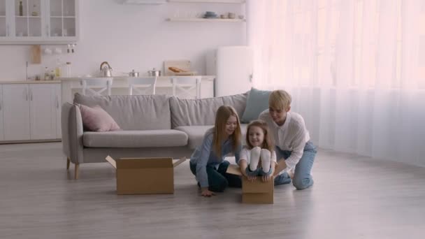 Mother And Daughters Riding In Boxes Having Fun At Home — Stock Video