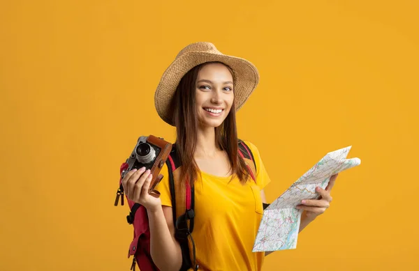 Gelukkig jong vrouw backpacker holding stad kaart en camera — Stockfoto