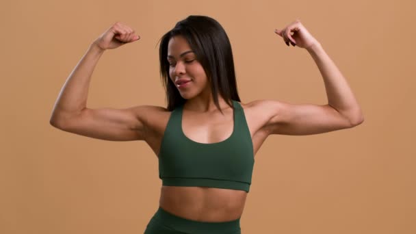 Athletic Black Lady Showing Biceps Muscles Over Beige Studio Background — Stock Video