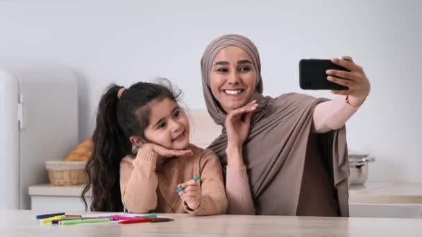 Muslimska mor och dotter gör selfie på smartphone hemma — Stockvideo