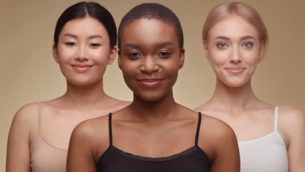 Разнообразие красоты. Счастливая американка из Африки широко улыбается в камеру, позирует с азиатскими и кавказскими подругами — стоковое видео