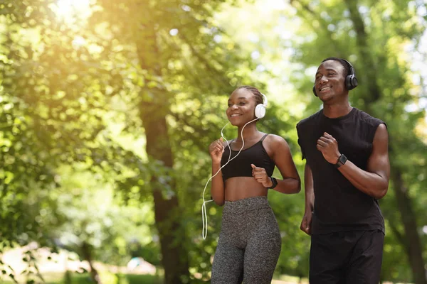 Allenamento cardio. Positivo afroamericano coppia jogging insieme in città parco — Foto Stock