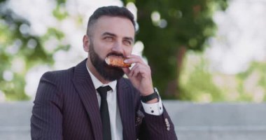 İş günü piknik. Huzurlu, olgun bir çalışan merdivenlerde oturuyor, pizza yiyor, öğle tatilini dışarıda geçiriyor.