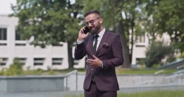 Başarılı iş görüşmeleri. Kendine güvenen işadamı, ortaklarıyla cep telefonuyla konuşuyor, anlaşmanın tadını çıkarıyor ve...