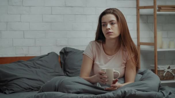 Depressive Dame trinkt Kaffee im Bett im dunklen Schlafzimmer — Stockvideo