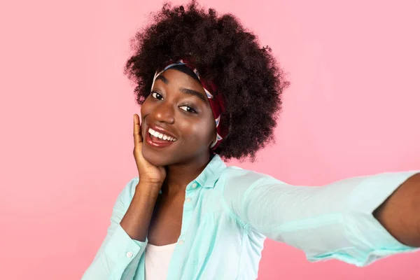 Csinos fekete nő csinál szelfi megható arc rózsaszín háttér — Stock Fotó