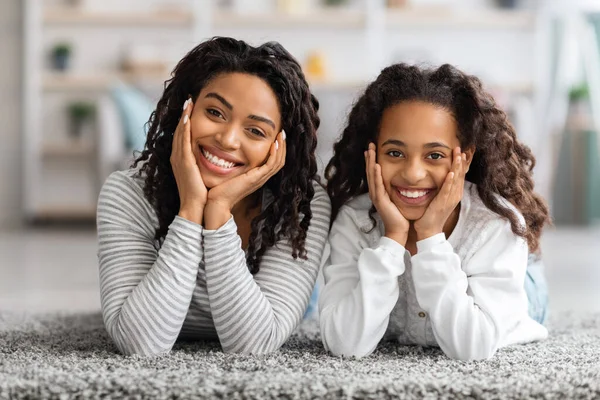 Adorable afroamericana madre e hija posando en la alfombra —  Fotos de Stock