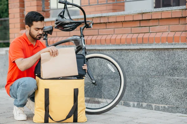 Correio na bicicleta no capacete de proteção entrega de alimentos na cidade e ordem on-line — Fotografia de Stock