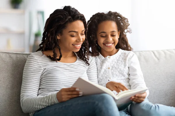 Lycklig svart mor och dotter läser bok tillsammans — Stockfoto