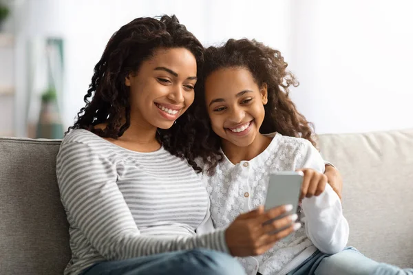 Alegre afro-americana mãe e filha usando smartphone juntos — Fotografia de Stock