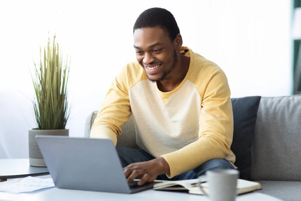 Positivo chico negro freelancer trabajando en línea desde casa — Foto de Stock