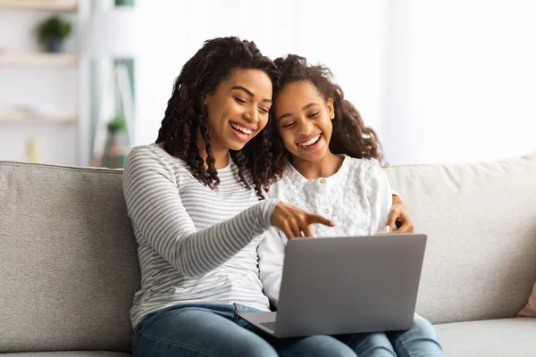 Opgewonden afrikaanse amerikaanse moeder en kind met behulp van laptop samen — Stockfoto