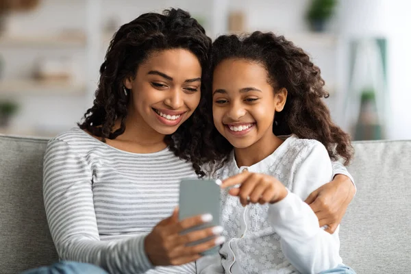 Glad afrikansk amerikansk mor och barn använder smartphone tillsammans — Stockfoto