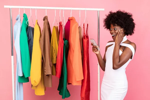 Mulher Africano excitado usando telefone com aplicativo de compras, fundo rosa — Fotografia de Stock