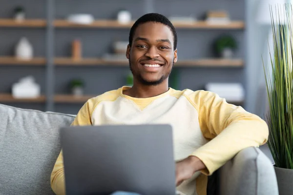 Close-up van vrolijke zwarte man met behulp van laptop — Stockfoto