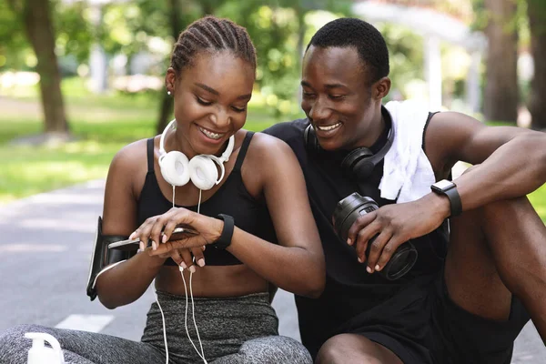 Allegro sportivo nero uomo e donna controllo fitness Tracker dopo l'allenamento all'aperto — Foto Stock