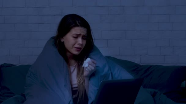 落ち込んだ女が夜の屋内でノートパソコンで映画を見て泣く — ストック動画