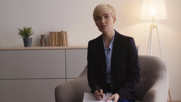 Professionell hjälp. Självsäker kvinnlig psykolog lyssnar på patienter och pratar, sitter på kontoret, ledigt utrymme — Stockvideo