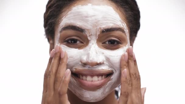 Pelado doméstico. Feliz mujer afroamericana aplicando limpieza de la cara del exfoliante, masajeando la piel y riendo a la cámara — Vídeos de Stock