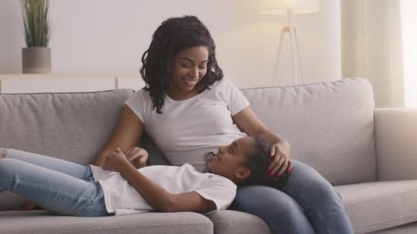 Anya-lánya kapcsolat. Fiatal afro-amerikai nő és lány beszél otthon együtt — Stock videók