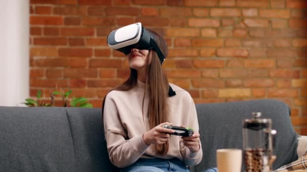 Mladá žena nosí VR sluchátka hrát videohry s joystick, těší rozšířený zážitek doma — Stock video