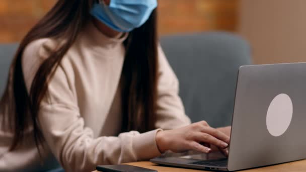 Extra personligt skydd. Ung panik kvinna som arbetar på bärbar dator hemifrån, bär tre skyddande masker i ansiktet — Stockvideo