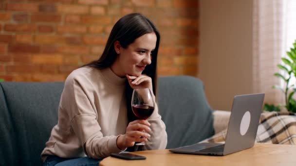 Romantisch afspraakje op afstand. Jongedame video chatten met vriendje online, toasten op laptop camera met glas wijn — Stockvideo