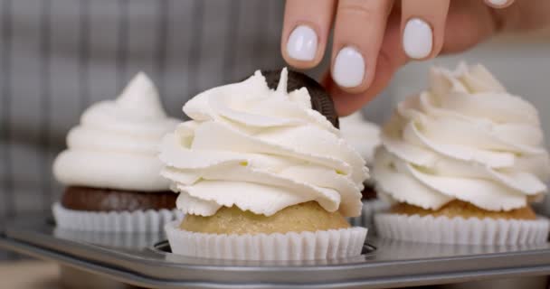 Panadería casera. Primer plano de mujer confitera decoración de cupcakes recién horneados con galletas y bayas frescas — Vídeo de stock