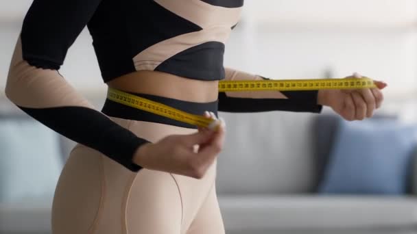 Africano americano fitness mujer medición cintura con cinta interior, recortado — Vídeos de Stock