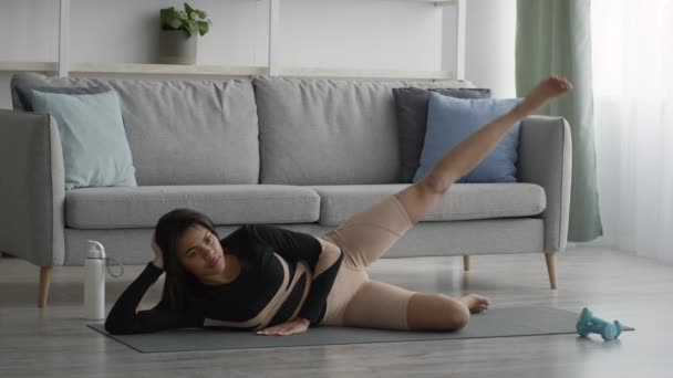 Afro-Amerikalı Kadın, evde bacak kaldırma egzersizi yapıyor. — Stok video