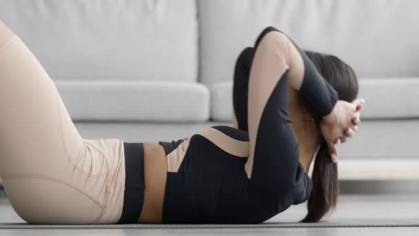 アフリカ人女性が自宅で横になって運動をする腹筋クランチをする様子 — ストック動画
