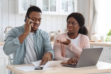 Mali sorunları olan Afrikalı eşler mutfaktaki ipotek kağıtlarını kontrol ediyor