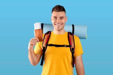 Sırt çantalı genç bir gezgin elinde uluslararası pasaport ve uçak biletleri var.