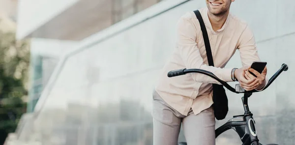 Jovem empresário caminhando ao ar livre com bicicleta e usando telefone celular, vai trabalhar em bicicleta — Fotografia de Stock