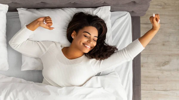 Satisfied young African American woman stretching after wake up — Stock Photo, Image