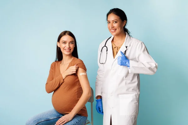 Wanita hamil Vaksinasi Dan Dokter Mendekati Imunisasi Coronavirus, Latar Belakang Biru — Stok Foto