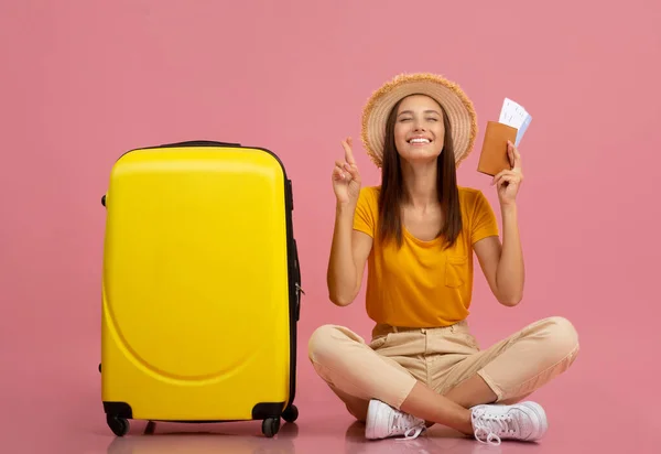 Giovane donna felice con passaporto seduta vicino alla valigia — Foto Stock