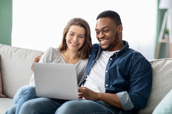 Weekend tijdverdrijf. Interraciaal paar met laptop ontspannen op bank in de woonkamer — Stockfoto
